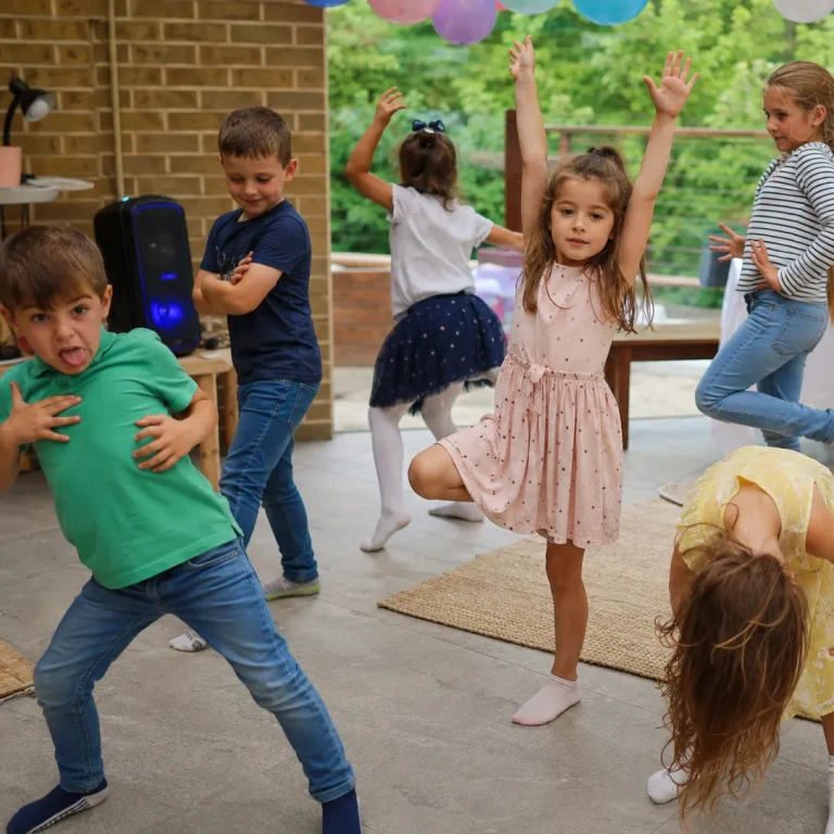 Children frozen in funny dance poses during a musical statues birthday party game