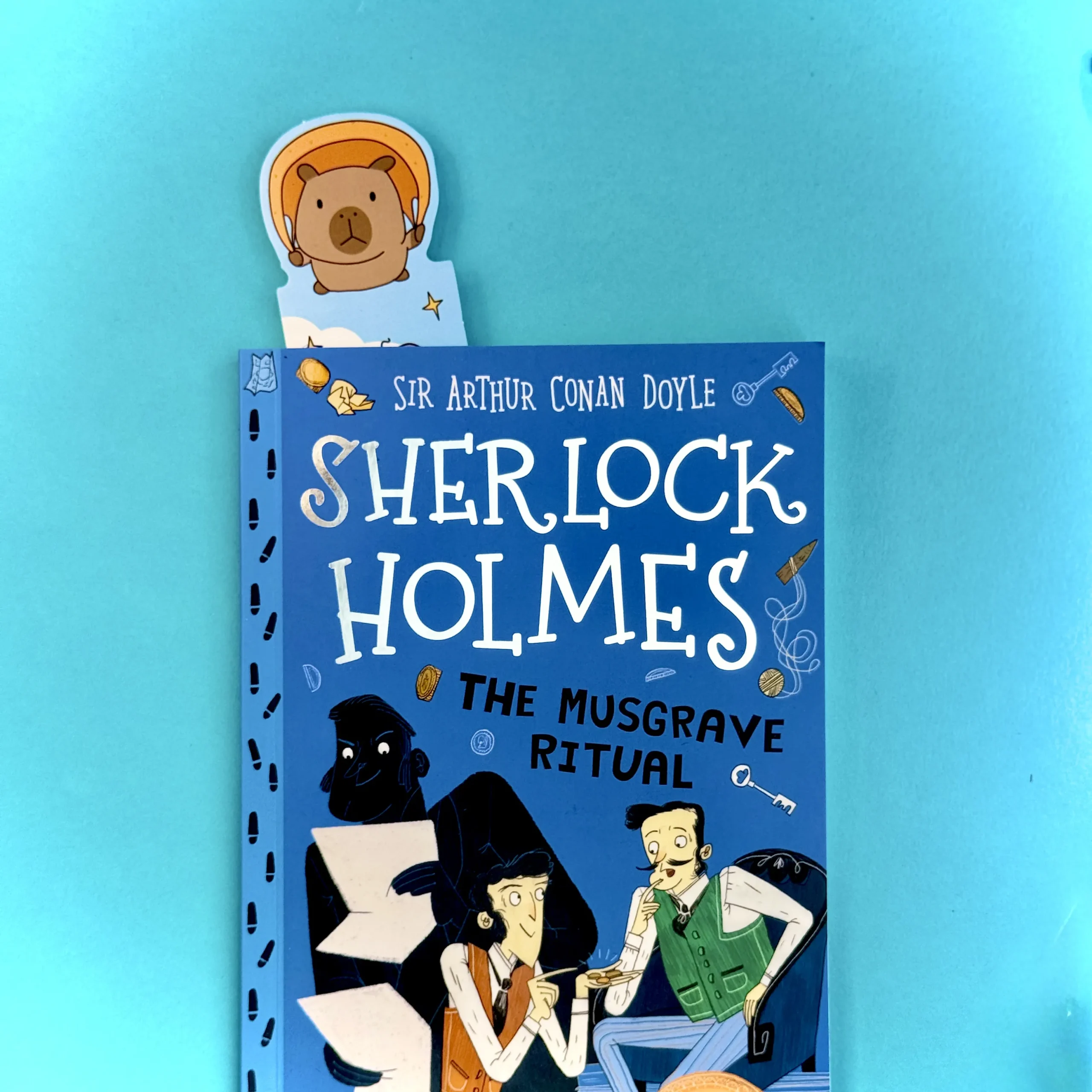 Capybara bookmark poking out of Sherlock Holmes book